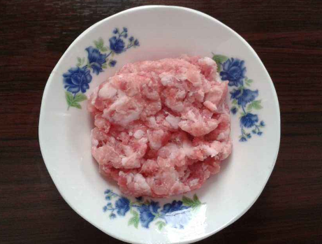 第四步,待猪肉末变色之后,淋入适量的酱油,再放入些许的香葱末,翻拌