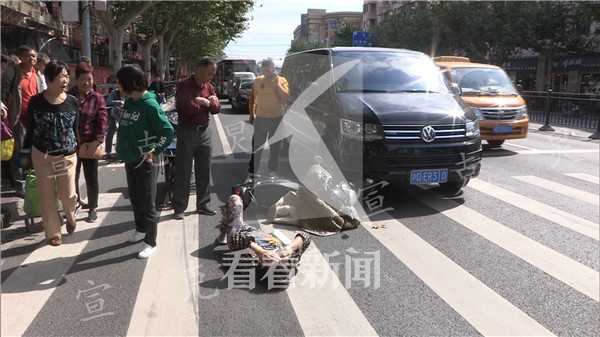 这名骑非机动车的女司机被商务车撞击后倒在了人行横道线上,她说自己