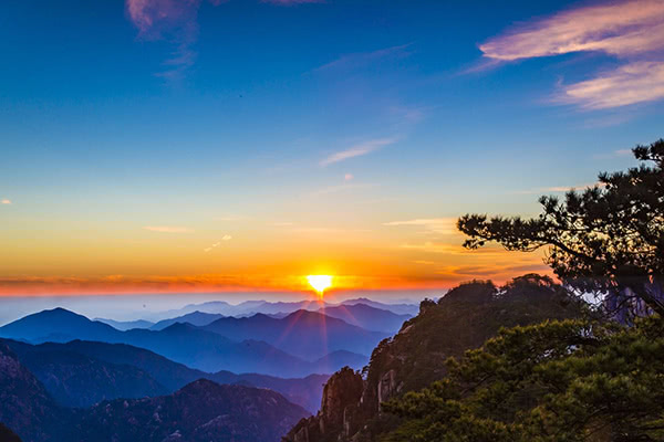 太阳西下,一抹橙红色的光辉照射在山水之上,从远处看就像是油画一样