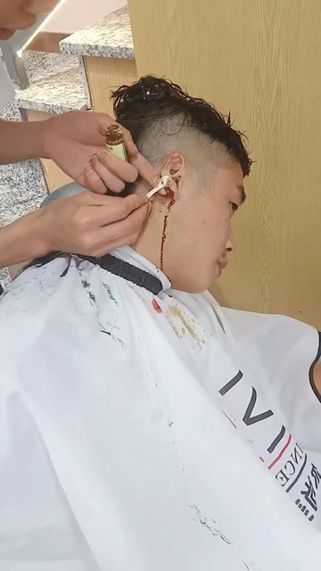 理发师手持剪刀为客户修剪发型的现场工作照