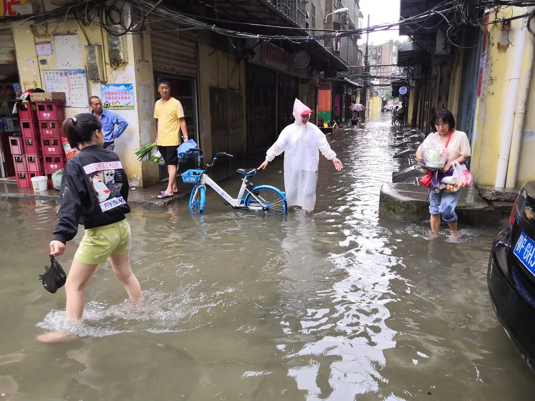 董家台社区居民区内涝严重,社区网格员在每个积水严重路口执勤,引导
