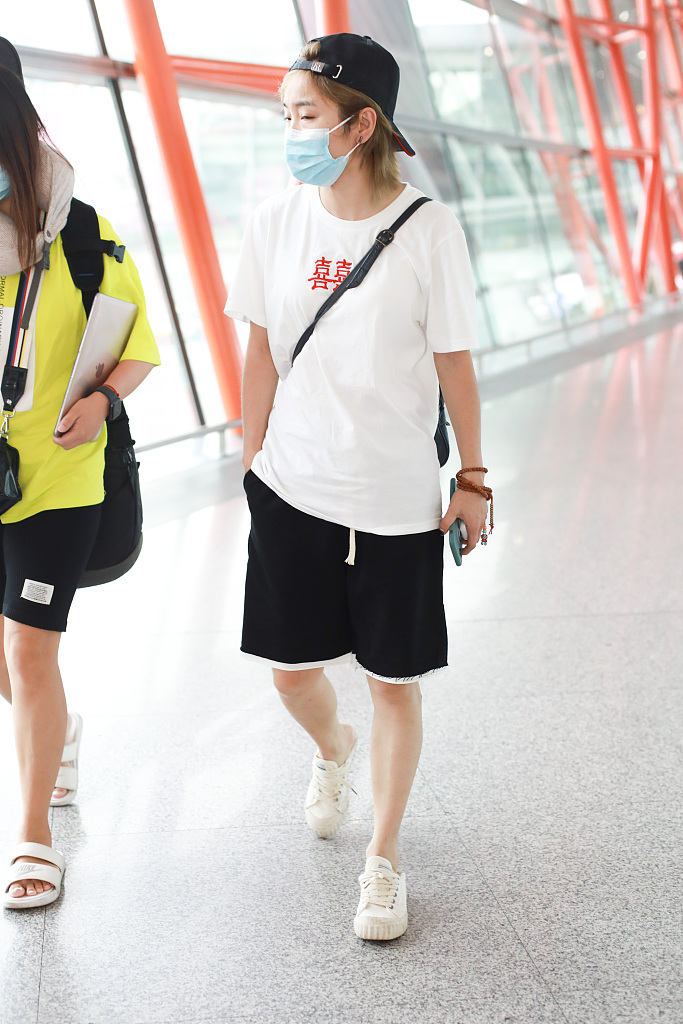 许飞机场整理秀发放飞自我穿双喜t恤造型中性十足