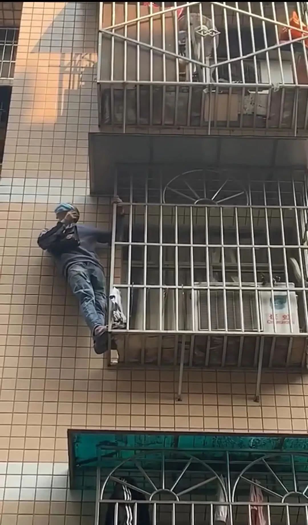 宜宾一19岁男子爬在自家四楼窗台外面的防护栏上,事情并不简单!