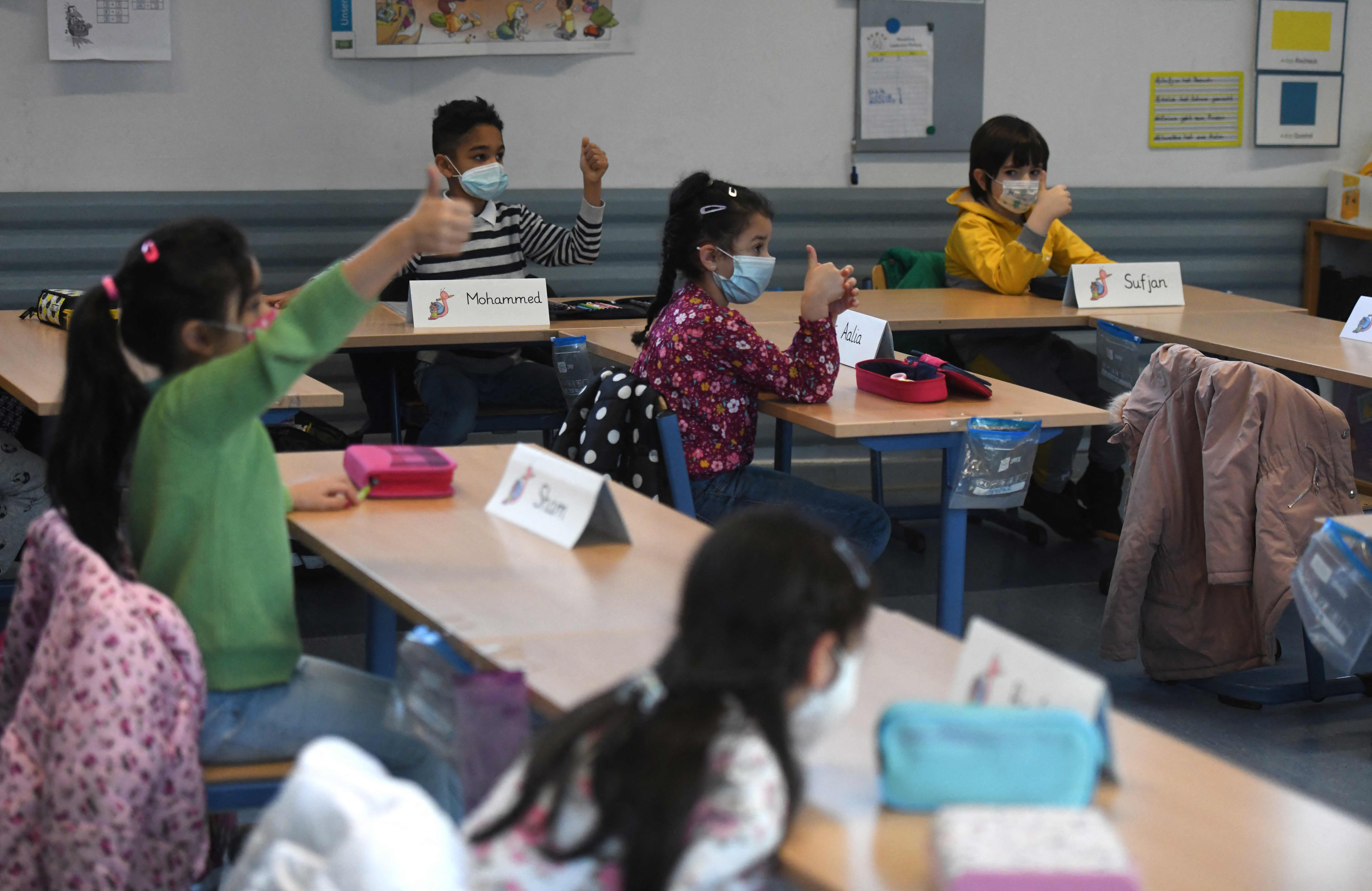 2月22日,在德国多特蒙德一所小学,学生戴着口罩上课.新华社/法新