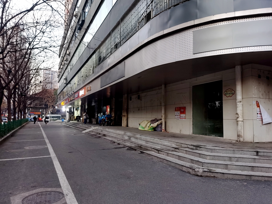 汉口闹市街头流浪汉堆放月余的杂物该清理啦